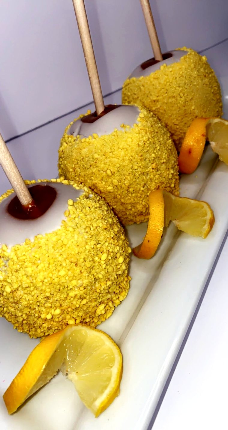 Lemon crumb candy apples styled on a white plate with lemon wheels